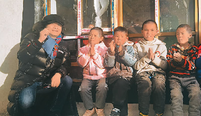 　舒楠（左一）参加文艺志愿活动，走进西藏定日县通来村，与当地孩子合影。 　　受访者供图