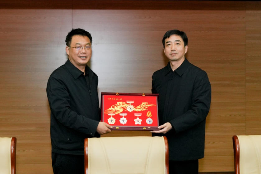 石家庄市公安局政治部主任崔勇向《中国作家》杂志社主编李云雷赠送纪念品。